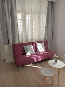 ムシアにあるapartamentos YEIKのリビングルーム(紫色のソファ、テーブル2台付)