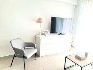 a living room with a chair and a tv at BEACH VALENCIA LUXURY D15-21 Apartment with terrace and sea views with two rooms in Valencia