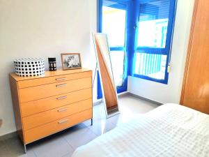 a bedroom with a dresser and a bed and a window at BEACH VALENCIA LUXURY D15-21 Apartment with terrace and sea views with two rooms in Valencia +13 photos
