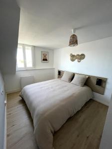 a bedroom with a large white bed in a room at Au pays des bretzels in Horbourg