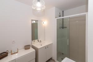 a white bathroom with a sink and a shower at Appartement BRISE MARINE in Labenne +18 photos