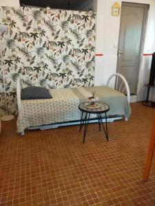 a room with a bed and a table and a wall at Appartement chaleureux à Fort-de-France, 50 m² avec terrasse in Fort-de-France
