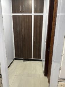 a room with wooden cabinets and a tile floor at Nizami menzil house in Dargai