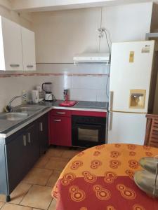 een keuken met een spoelbak en een fornuis bovenste oven bij Charmant appartement à Fort-de-France de 25 m² in Fort-de-France