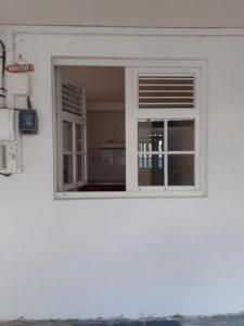 een raam in een wit gebouw met bij Charmant appartement à Fort-de-France de 25 m² in Fort-de-France