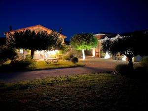 a home at night with a driveway and trees at Le Domaine d'Adrien in Larnage