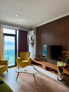 - un salon avec une télévision, un canapé et des chaises dans l'établissement Metrocity residence d, à Batoumi