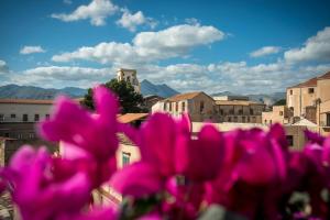 a view of a city with pink flowers in the foreground at Dimora Torremuzza in Palermo