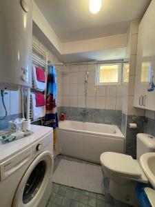 a bathroom with a toilet sink and a washing machine at Velvet Living Luxury Apartment in Skopje