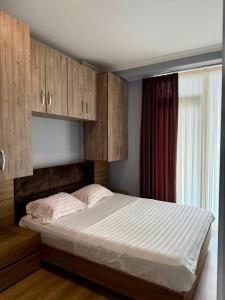 - une chambre avec un grand lit et des placards en bois dans l'établissement Metrocity residence d, à Batoumi