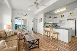 a living room and kitchen with a couch and a table at CR201 Salty Tides in Kill Devil Hills
