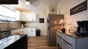 een keuken met witte kasten en een roestvrijstalen koelkast bij Honey Pot House in Novi
