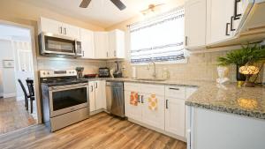 een keuken met witte kasten en roestvrijstalen apparaten bij Honey Pot House in Novi +12 foto's