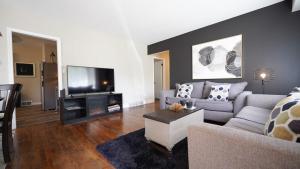 een woonkamer met een bank en een tv bij Honey Pot House in Novi