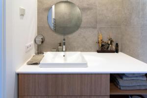 Un baño con un lavabo blanco y un espejo. en Algirdo central stay, en Vilna