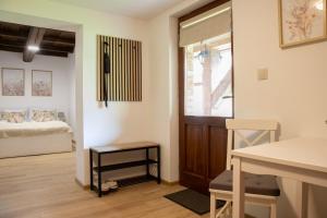 a room with a bed and a table and a door at Vadvirág Apartman Gyula 2 in Gyula