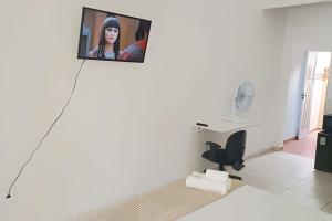 a tv hanging on a wall in a living room at Autonomia em Niterói com praticidade e conforto in Niterói