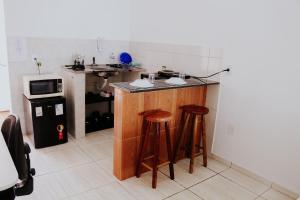 a kitchen with a counter with stools and a microwave at Autonomia em Niterói com praticidade e conforto in Niterói