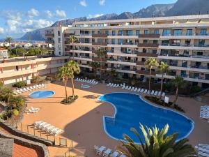 une image d'un hôtel avec une piscine et des chaises dans l'établissement Balcón De Los Gigantes, Puerto de Santiago, à Puerto de Santiago