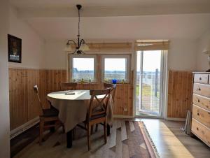 a dining room with a table and chairs and windows at Cabin outside Sösdala in Sösdala
