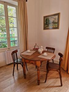a wooden table and chairs in a room with a window at Les Demeures du Parc, la Bourbonnaise, proche des Thermes in Bourbon-lʼArchambault