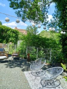 a patio with two chairs and a table and chairs at Gîte de charme Abelia avec extérieur au calme in Lavaur