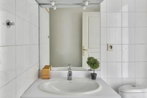 a bathroom with a sink and a toilet and a mirror at O métro Jean jaures in Lyon