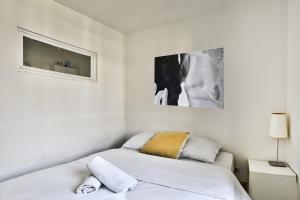 a white room with two beds and a tv at O métro Jean jaures in Lyon