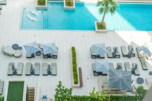 eine Draufsicht auf einen Pool mit Stühlen und Sonnenschirmen in der Unterkunft Chalet Homes - LUX New Studio With 2 Double Beds in Downtown Dubai in Dubai