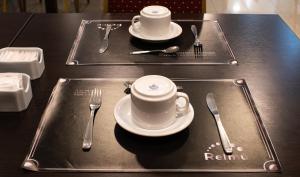a table with two plates and two cups and forks and knives at Posada Relmú in Neuquén