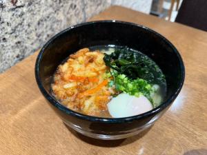 a black bowl of food on a table at APA Hotel Keikyukamata Ekimae in Tokyo