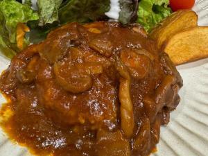 a plate of food with meat and sauce on it at APA Hotel Keikyukamata Ekimae in Tokyo
