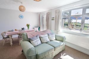 a living room with a couch and a table and windows at The Seaside Inn in Seaton