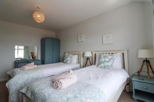 two beds in a bedroom with pink towels on them at The Seaside Inn in Seaton