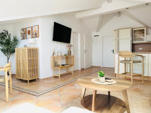 a living room with a table and a tv at HAFENROMANTIK - Wohnen mit Charme im Herzen von Neustadt mit Blick auf das Binnenwasser in Neustadt in Holstein
