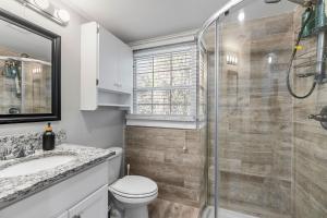 a bathroom with a toilet and a glass shower at Downtown Cottage Hammond, Pool, Hot Tub, King Bed in Hammond