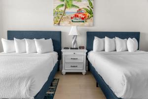 two beds sitting next to each other in a bedroom at Modern & Updated Oceanview Studio! Sleeps 4! Landmark 523 in Myrtle Beach