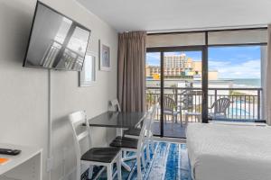 a room with a table and a bed and a balcony at Modern & Updated Oceanview Studio! Sleeps 4! Landmark 523 in Myrtle Beach