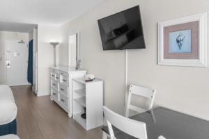a living room with a television on a wall at Modern & Updated Oceanview Studio! Sleeps 4! Landmark 523 in Myrtle Beach