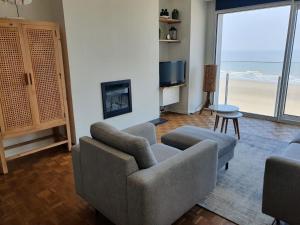 a living room with a couch and chairs and a television at Residentie Majestic in Middelkerke