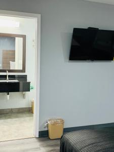 a bathroom with a sink and a television on the wall at EXPRESS INN & Suites in El Campo +7 photos