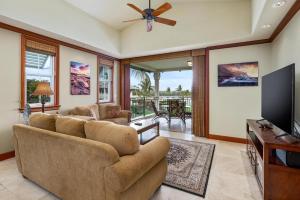 Una sala de estar con un sofá y un televisor de pantalla plana. en Big Island Kolea 11C by Coldwell Banker Island Vacations, en Waikoloa