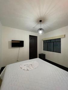 a bedroom with a large white bed with a ceiling at Hotel & Restaurante Teresàs Bistro in Antigua Guatemala