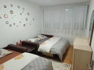 una camera da letto con due letti e un orologio a parete di MedO a Čapljina