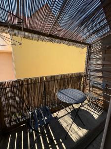 a patio with a table and chairs and a fence at L'ESCALE SELESTADIENNE in Sélestat