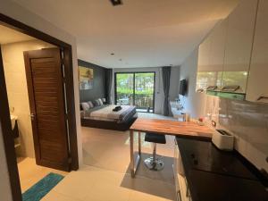 a kitchen and a bedroom with a bed in the background at Emerald Terrace Condo 3-Studio Garden Gem in Patong Beach