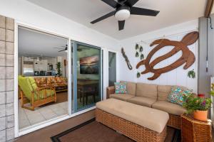 a living room with a couch and a ceiling fan at Big Island Alii Villas 333 by Coldwell Banker Island Vacations in Kailua-Kona