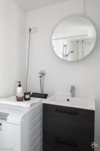 un bagno con lavandino e specchio di Valoisa 44,5 m2 kaksio Lahden keskustassa a Lahti