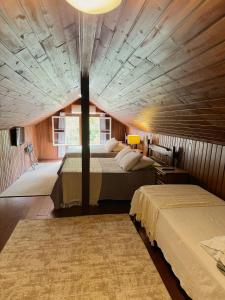 a bedroom with two beds and a large ceiling at HMG Morada & Chalet - Centro histórico in Petrópolis