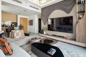 a living room with a couch and a tv at qua Serenity Poolside with Community Views in Dubai